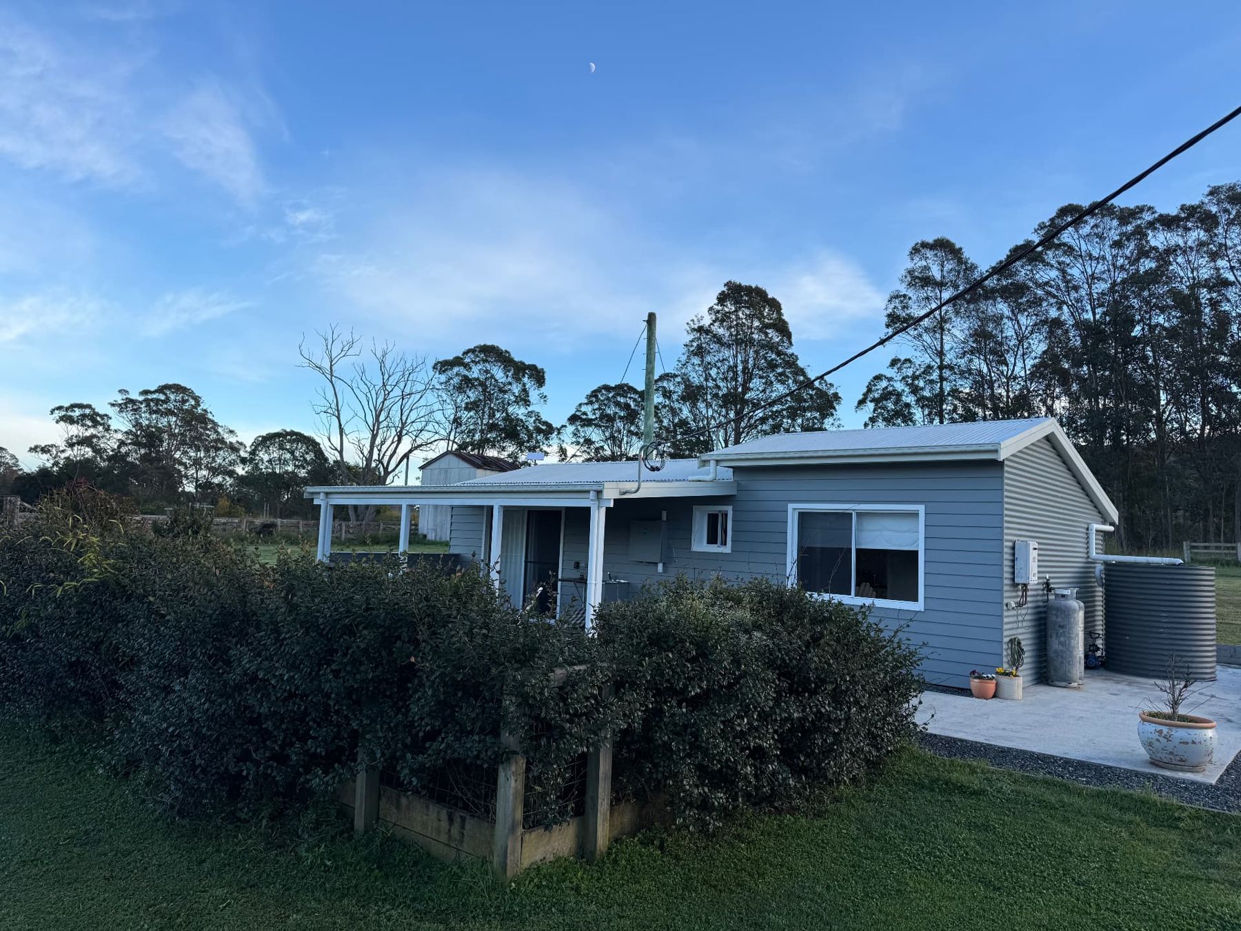 The cottage and green paddocks on the farm at Nabiac